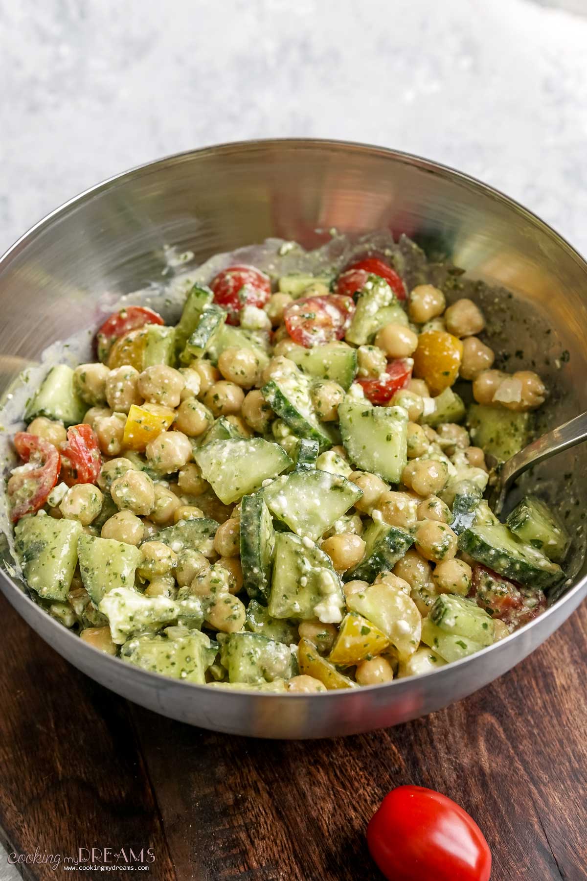 chickpea salad in a silver bowl with a spoon.